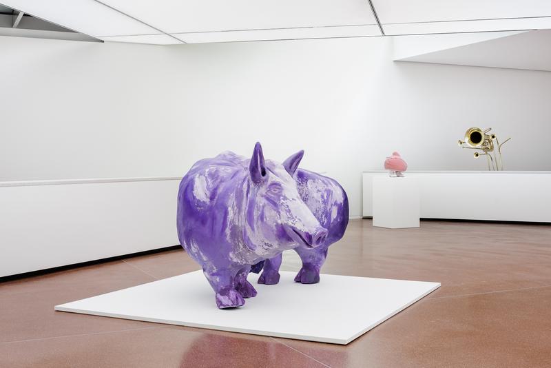 Lila Skulptur eines Tieres in einem modernen Ausstellungsraum mit minimalistischer Einrichtung.