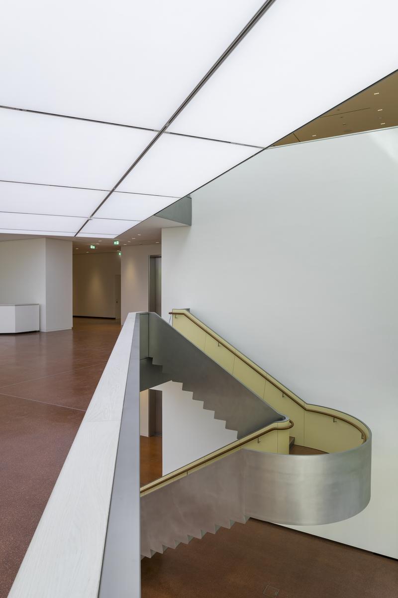 Heller Innenraum mit geschwungener Treppe, weißen Wänden und einem modernen, minimalistischen Design.