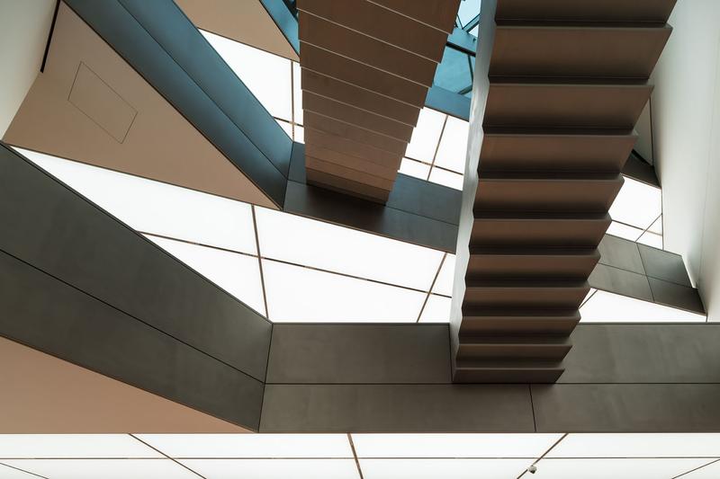 Schwebende Treppen in modernem Architekturdesign, umgeben von geometrischen Formen und hellem Licht.