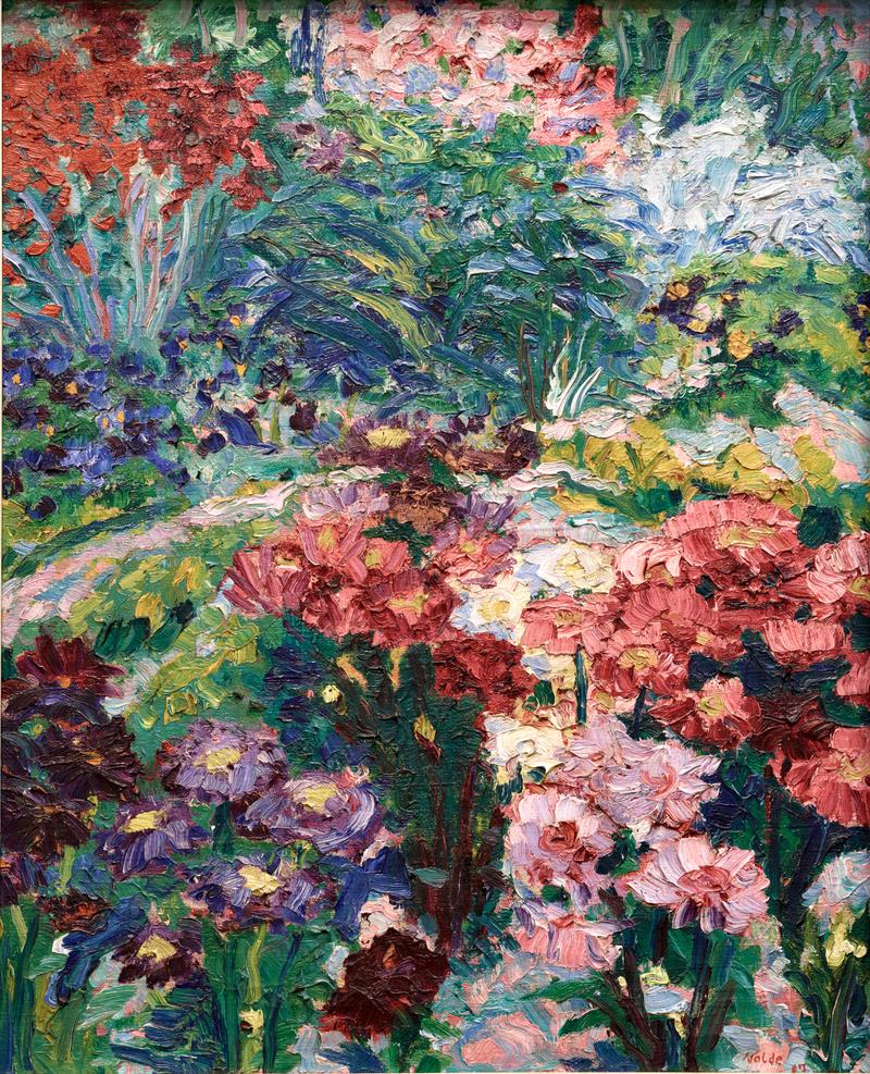 Bunte Blumen in verschiedenen Farben und Formen, umgeben von grünem Laub und einem geschwungenen Weg.