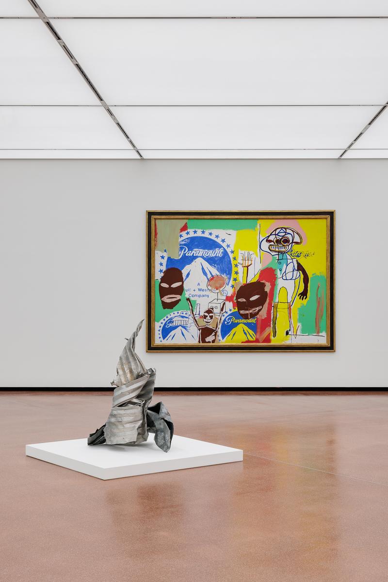 Moderne Galerie mit einer abstrakten Skulptur und einem bunten Gemälde im Hintergrund.