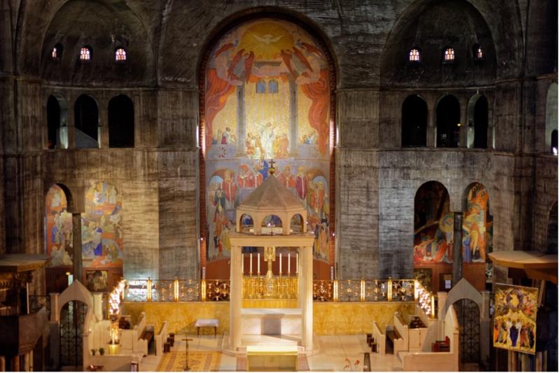 Innenansicht der Église Saint-Esprit mit bunten Wandmalereien und einem zentralen Altar.