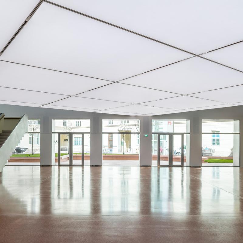 Helle, moderne Innenarchitektur mit großen Fenstern, Treppe und glänzendem Boden.