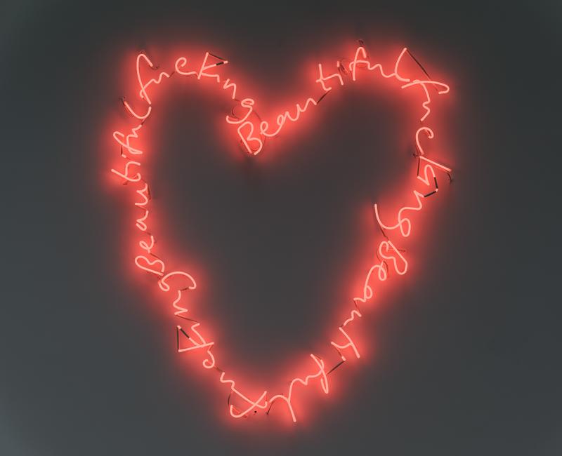 Neoninstallation in Herzform mit der Schrift "fucking beautiful" in leuchtendem Rot auf grauem Hintergrund.
