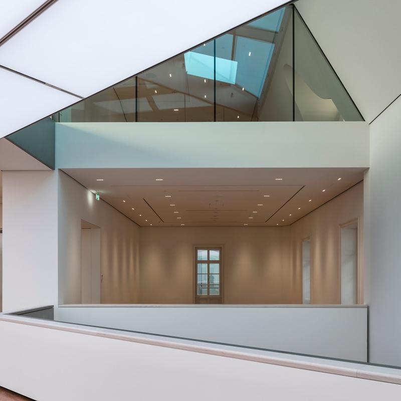 Moderne Architektur mit hellen Wänden, Glasdetails und einem offenen Raumkonzept.